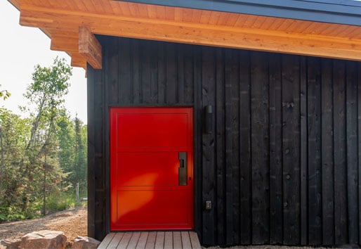 Red entry door on black house
